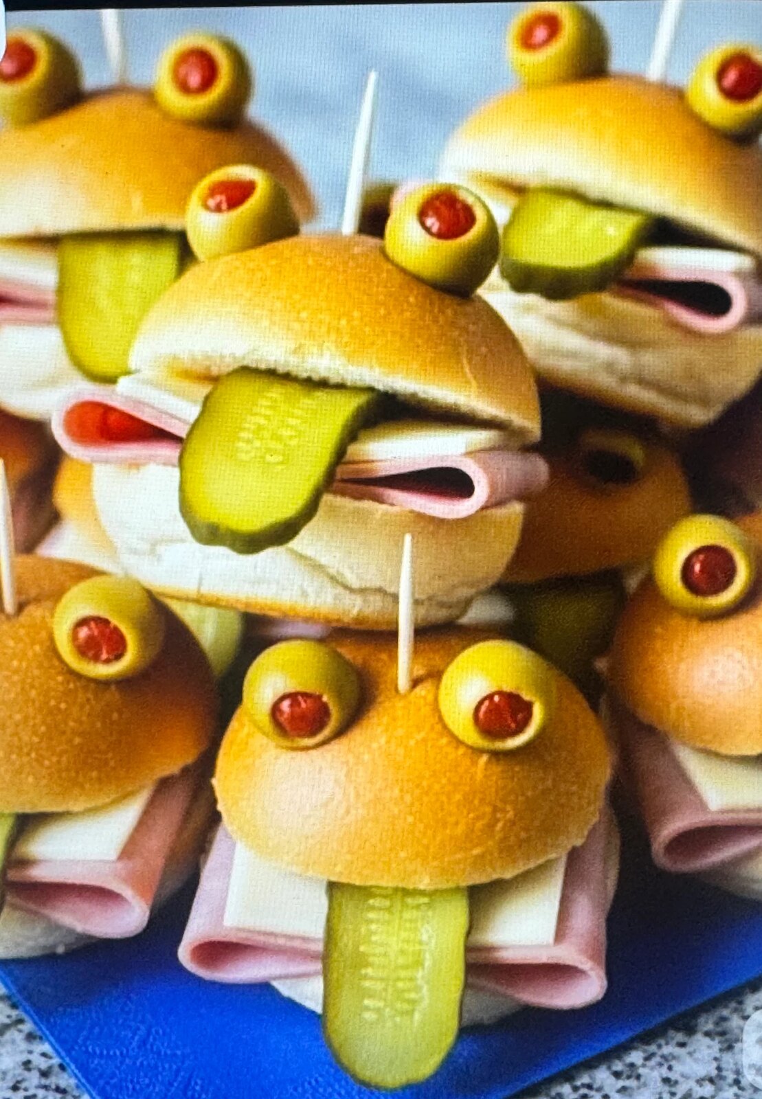 Mini sliders styled as characters with olive eyes and gherkin tongues