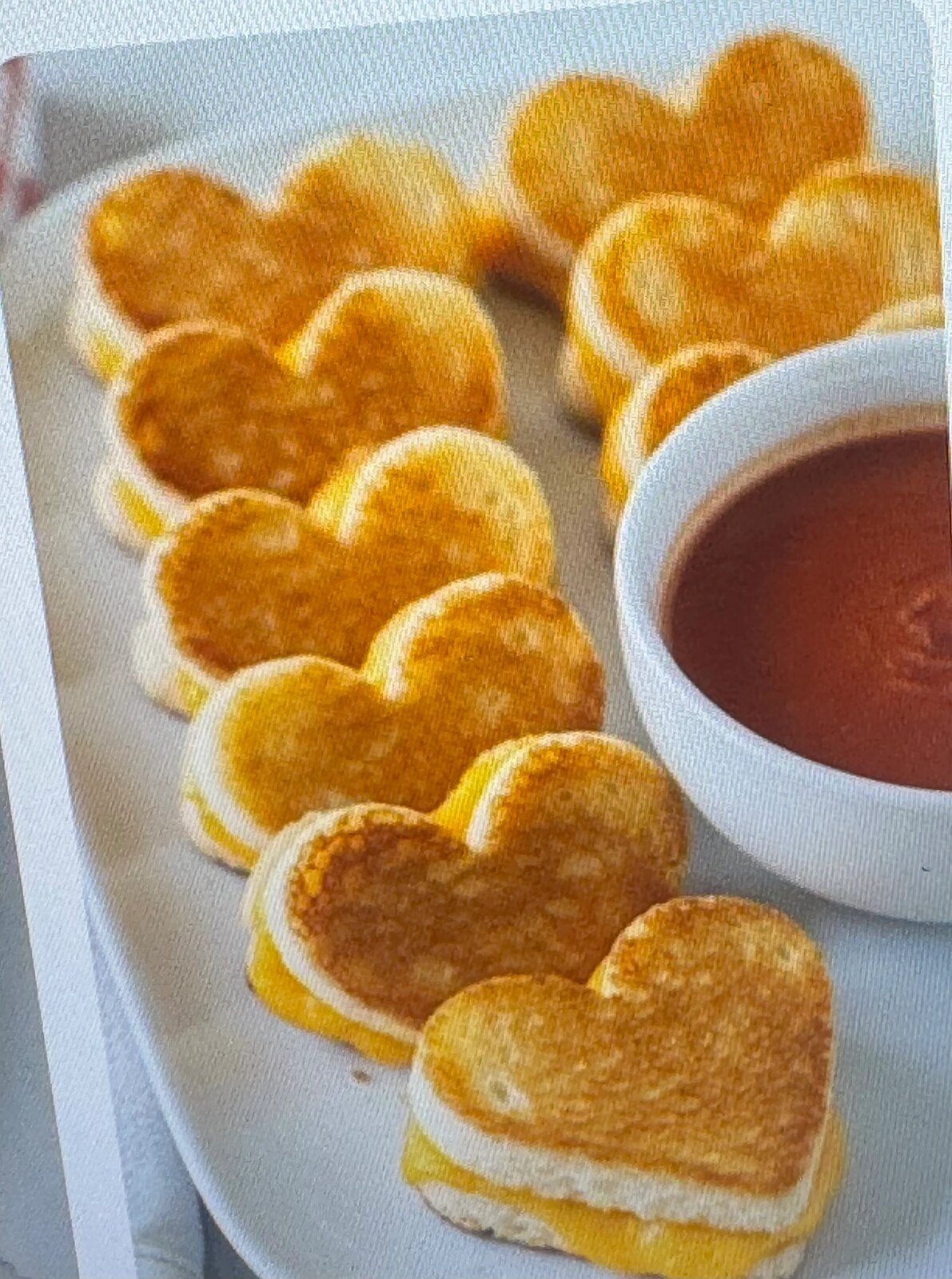 Heart-shaped toasted sandwiches served with tomato dip